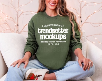 May include: An olive green crewneck sweatshirt featuring white text that reads: REAL-MODEL MOCKUPS, trendsetter mockups, AUTHENTIC PRODUCT PHOTOGRAPHY, FOR POD - NO 01. The sweatshirt has long sleeves and a ribbed collar, cuffs, and hem.