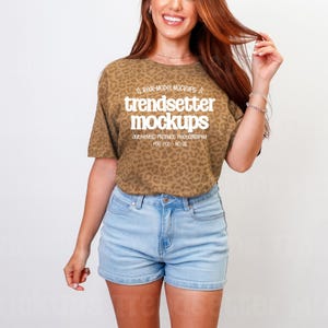 Puede incluir: Una camiseta con estampado de leopardo marrón con texto en blanco que dice "real-model mockups", "trendsetter mockups" y "authentic product photography for pod - no ai" combinada con pantalones cortos de mezclilla azul claro.