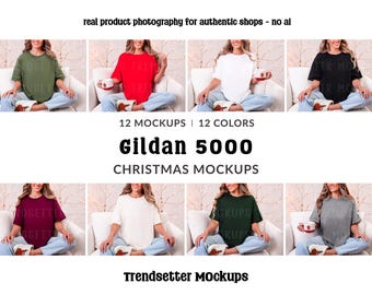 May include: A mockup image featuring a variety of Gildan 5000 t-shirts in different colors, including green, red, white, and black. The text "12 MOCKUPS | 12 COLORS" and "CHRISTMAS MOCKUPS" is displayed. The phrase "real product photography for authentic shops - no ai" is also visible.