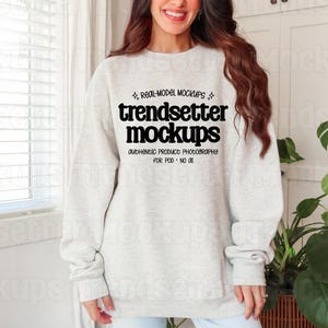 May include: A light gray crewneck sweatshirt featuring black text on the chest that reads: REAL-MODEL MOCKUPS, trendsetter mockups, authentic product photography, FOR POD - NO AI. The garment has long sleeves and a ribbed collar, cuffs, and hem.