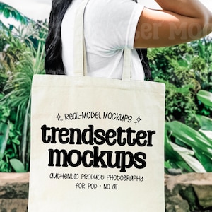 Puede incluir: Un bolso tote de color crema con el texto "trendsetter mockups" en negro. El bolso lo sostiene una persona que lleva una camiseta blanca. Tambi&eacute;n se ve el texto "REAL-MODEL MOCKUPS" y "AUTHENTIC PRODUCT PHOTOGRAPHY FOR POD &bull; NO AI".