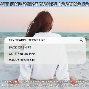 a woman sitting on the beach looking at the ocean