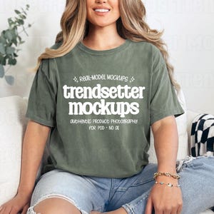May include: An olive green t-shirt with the text "trendsetter mockups" in white. The shirt is worn by a person sitting on a white couch. The text "REAL-MODEL MOCKUPS" and "AUTHENTIC PRODUCT PHOTOGRAPHY FOR POD - NO AI" are also visible.