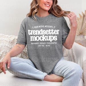 May include: A grey t-shirt featuring the white text "trendsetter mockups". The shirt has a crew neck and is being worn. The text "authentic product photography for POD - NO AI" is also visible on the shirt.