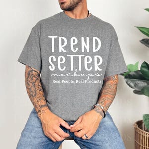 May include: A gray t-shirt with the text "TREND SETTER mockups Real People, Real Products" in white. The shirt is worn with blue jeans. The image is a product mockup.