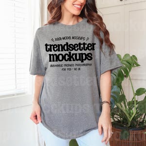 May include: A grey t-shirt featuring the text "trendsetter mockups" in black. The shirt has short sleeves and a loose fit. The text "REAL-MODEL MOCKUPS" and "AUTHENTIC PRODUCT PHOTOGRAPHY FOR POD - NO AI" are also visible.