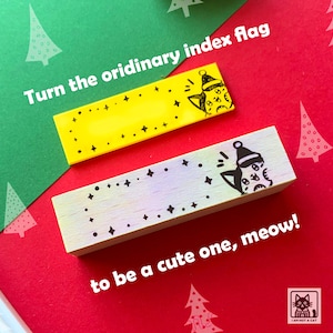 May include: Two wooden index flag stamps with a cat design. The top stamp is yellow with black stars and the bottom stamp is light purple with black stars. The text on the image reads "Turn the ordinary index flag to be a cute one, meow!"