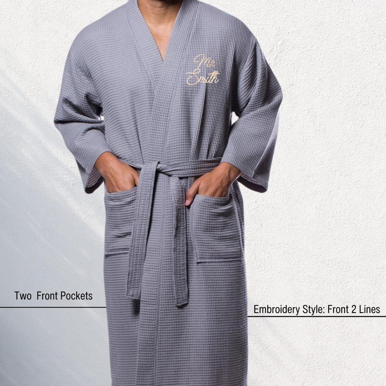 May include: Gray waffle-weave robe with a matching belt and two front pockets. The robe has an embroidered design on the chest that reads "Mr. Smith". The text "Two Front Pockets" and "Embroidery Style: Front 2 Lines" are also visible.