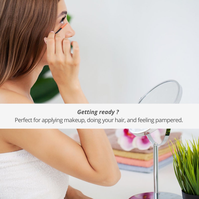 Pu&ograve; includere: Una donna con un asciugamano bianco si sta truccando davanti a uno specchio. Il testo "Getting ready? Perfect for applying makeup, doing your hair, and feeling pampered." &egrave; visualizzato sotto l'immagine.