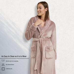 May include: A dusty rose-colored robe with a shawl collar and a matching belt. The robe has two front pockets and textured cuffs. The text "As Easy to Clean as it is to Wear" is visible, along with washing instructions.