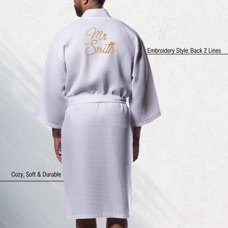 May include: White waffle-weave robe with gold embroidered text "Mr Smith" on the back. The robe has a matching belt and short sleeves. The text "Embroidery Style: Back 2 Lines" is visible. The text "Cozy, Soft & Durable" is also visible.