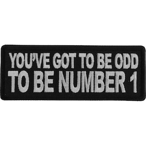 Puede incluir: Parche bordado negro con texto blanco que dice "You've got to be odd to be number 1".