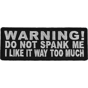 May include: Black and white embroidered patch with the text "WARNING! DO NOT SPANK ME I LIKE IT WAY TOO MUCH".