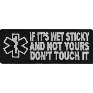 May include: Black embroidered patch with a white star of life and the text "If it's wet sticky and not yours don't touch it".
