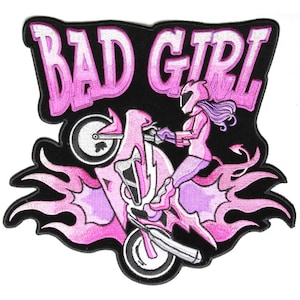 May include: Pink and white embroidered patch with the text "Bad Girl" and a woman riding a motorcycle with flames coming out of the back tire.