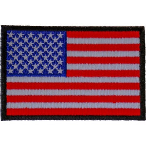 Può includere: Un piccolo patch ricamato della bandiera americana con stelle e strisce rosse, bianche e blu. Il patch ha un bordo nero.