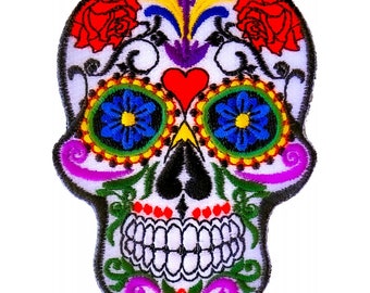 May include: A colorful embroidered sugar skull patch with red roses, blue and yellow flowers, and a red heart. The skull is white with black outlines and intricate details.