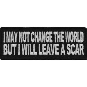 Peut inclure: Écusson brodé noir avec du texte blanc qui dit "Je ne changerai peut-être pas le monde, mais je laisserai une cicatrice."