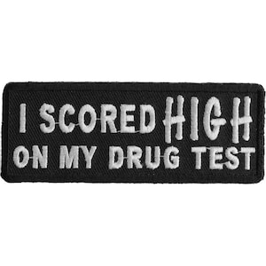 May include: Black rectangular patch with white embroidered text that reads "I SCORED HIGH ON MY DRUG TEST". The patch has a stitched border.