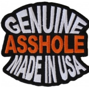 May include: Black and white embroidered patch with the text "GENUINE ASSHOLE MADE IN USA" in a white outline. The word "ASSHOLE" is in orange.