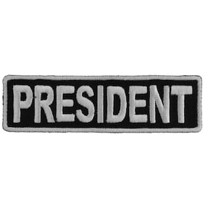 May include: Black and white embroidered patch with the word "PRESIDENT" in white lettering.