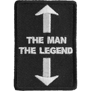 May include: Black embroidered patch with white text and arrows. The text reads "The Man The Legend".