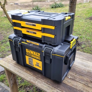 May include: A black and yellow DeWalt ToughSystem 2.0 toolbox with two smaller black and yellow toolboxes stacked on top. The smaller toolboxes have the word "STAK" printed on them.