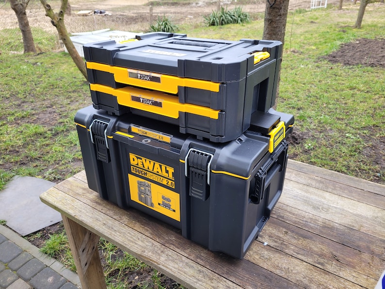 May include: A black and yellow DeWalt ToughSystem 2.0 toolbox with two smaller black and yellow toolboxes stacked on top. The smaller toolboxes have the word "STAK" printed on them.