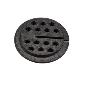 May include: Black 3D-printed tool organizer. The organizer is circular with two tiers, each with hexagonal holes. A slot is cut into the side. The design is suitable for organizing small tools or components.