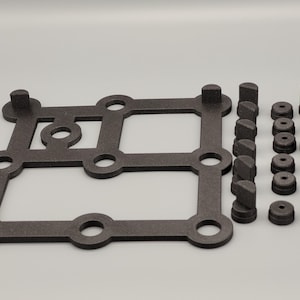 Puede incluir: Una base de espuma negra con ocho agujeros circulares y una sección central elevada. Hay 18 piezas de espuma negra de diferentes formas y tamaños.