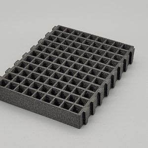 May include: A black plastic grid with a textured surface. The grid is rectangular in shape and is made up of small squares.