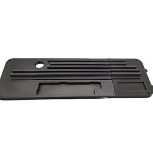 May include: A black, rectangular 3D-printed component with various recessed sections, including a circular hole and several parallel ridges. The component has a matte finish and appears to be a part of a larger assembly.