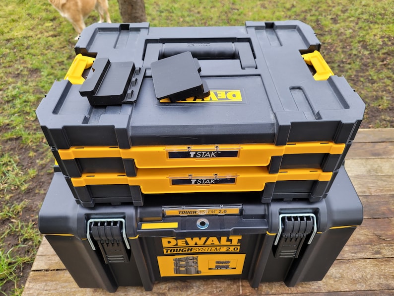 May include: A stack of three black and yellow DeWalt ToughSystem 2.0 tool boxes. The top box has a black T-STAK label. The middle box has a black T-STAK label. The bottom box has a black DeWalt ToughSystem 2.0 label.
