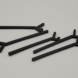 May include: Several black metal shelf supports are arranged on a light gray surface. The supports have a distinctive angular design, with straight bars and right-angle bends. The supports are likely for a shelving unit.
