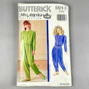 May include: A vintage sewing pattern for a girls' outfit. The pattern is for a green and a purple outfit with a jacket and pants. The pattern is from the Miss America Collection by Butterick and is size 7-8-10.