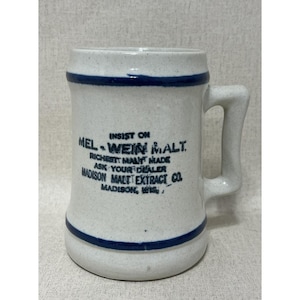 May include: A vintage stoneware beer mug with a handle. The mug is off-white with blue bands at the top and bottom. Text on the front reads "MEL-WEIN MALT" and "MADISON MALT EXTRACT CO."