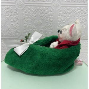May include: A white plush mouse wearing a red coat is nestled in a green felt stocking with a white bow and holly sprig.