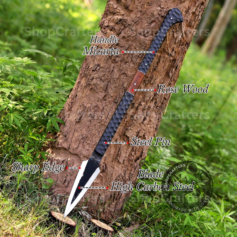 K&ouml;nnte beinhalten: Ein handgefertigter Speer mit einem schwarzen Micarta-Griff, Akzenten aus Rosenholz und einer Klinge aus hochfestem Kohlenstoffstahl. Die Klinge hat eine scharfe Kante. Der Text "ShopCrafters" ist sichtbar.