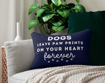 May include: A navy blue throw pillow with white text that reads "Dogs leave paw prints on your heart forever" with paw prints below the text.