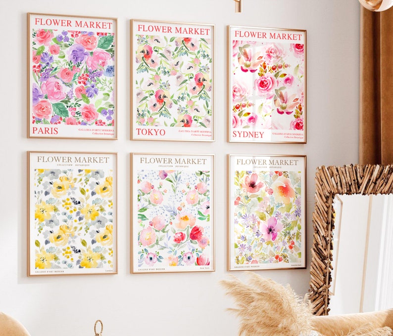 May include: Six framed floral art prints. Each print features a watercolor floral design with the words "FLOWER MARKET" at the top and a city name at the bottom. The prints showcase various flowers in shades of pink, purple, yellow, and red.