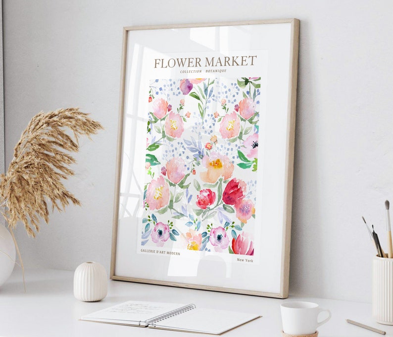 May include: Framed floral art print featuring a watercolor design of pink, red, and purple flowers with green leaves and blue accents. The print is titled "Flower Market" with text that reads "Collection Botanique" and "Galerie d'Art Modern, New York."
