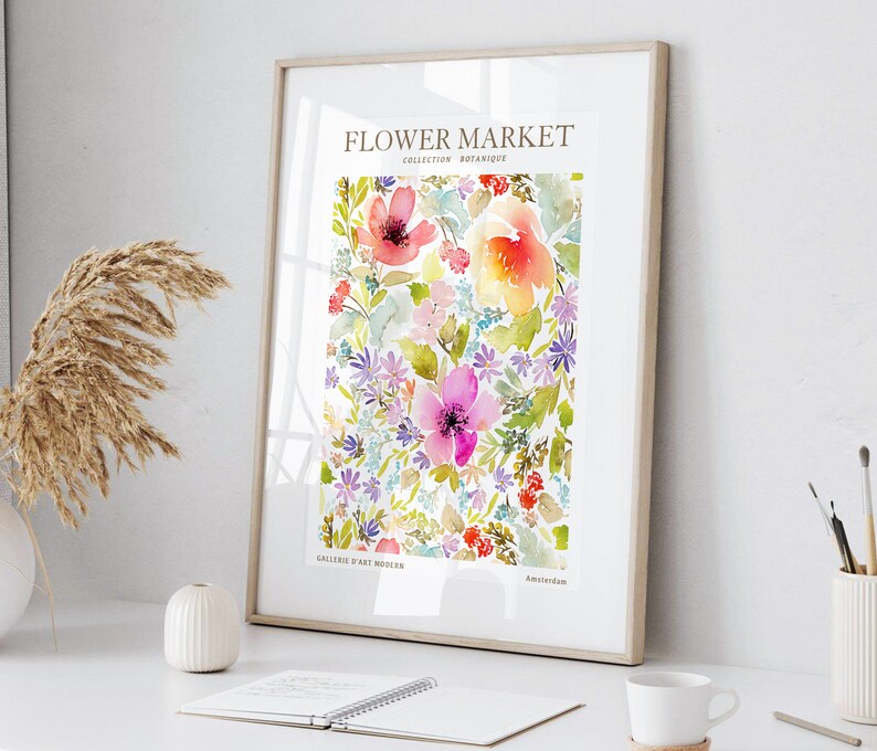 May include: A framed watercolor print featuring a vibrant floral design. The artwork showcases a variety of colorful flowers in shades of pink, red, yellow, and purple, with green foliage. The print includes the text "Flower Market" and "Collection Botanique".