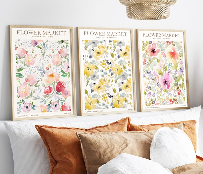 May include: Three framed floral art prints. Each print features a watercolor floral design in shades of pink, yellow, and purple. The text "FLOWER MARKET" is at the top of each print, with "Collection Botanique" below.