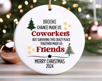 May include: White ceramic Christmas ornament with a red and black design. The ornament features the text "Brooke Chance Made Us Coworkers But Surviving This Crazy Place Together Made Us Friends Merry Christmas 2024".
