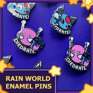 Op de afbeelding: Vier emaillepins met personages uit het videospel Rain World. De pins zijn blauw, roze en zwart met witte accenten. De pins tonen de tekst "Hydrate!" en "Diedrate!"