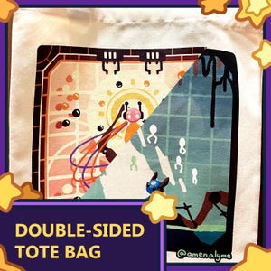 Op de afbeelding: Crèmekleurige dubbelzijdige tote bag. Eén kant toont een kleurrijke, abstracte illustratie met een zonachtig ontwerp en een roze karakter. De andere kant heeft een blauw-groene scène met witte figuren. Tekst: "DOUBLE-SIDED TOTE BAG".