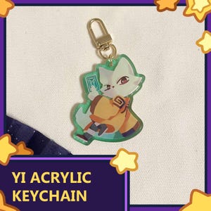 Puede incluir: Un llavero acrílico verde con un personaje de zorro de dibujos animados con un atuendo amarillo y naranja. El llavero tiene un cierre dorado. El texto "YI ACRYLIC KEYCHAIN" se muestra en letras blancas sobre un fondo púrpura.