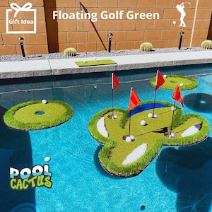 May include: Floating golf green game set for a pool. The set includes three green islands with flags and holes, and white golf balls. The game is floating in a blue pool with a blue and white pool cactus logo in the bottom left corner. The text "Floating Golf Green" is visible at the top of the image.