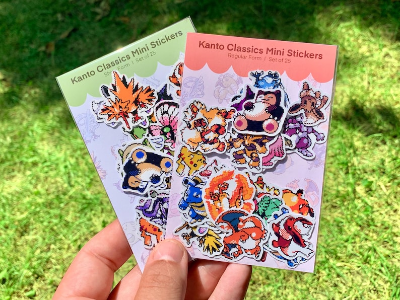 Pu&ograve; includere: Due confezioni di adesivi Kanto Classics Mini. Una confezione &egrave; verde con la scritta "Ship Form I Set of 25". L'altra confezione &egrave; rosa con la scritta "Regular Form I Set of 25". Ogni confezione contiene adesivi di cartoni animati colorati.