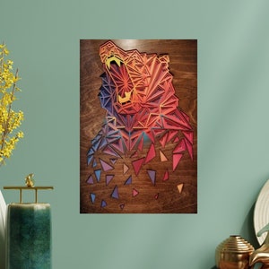 Könnte beinhalten: Ein Wandbild aus Holz mit einem geometrischen Design eines Bärenkopfes in Rot-, Orange-, Gelb-, Blau- und Violetttönen.